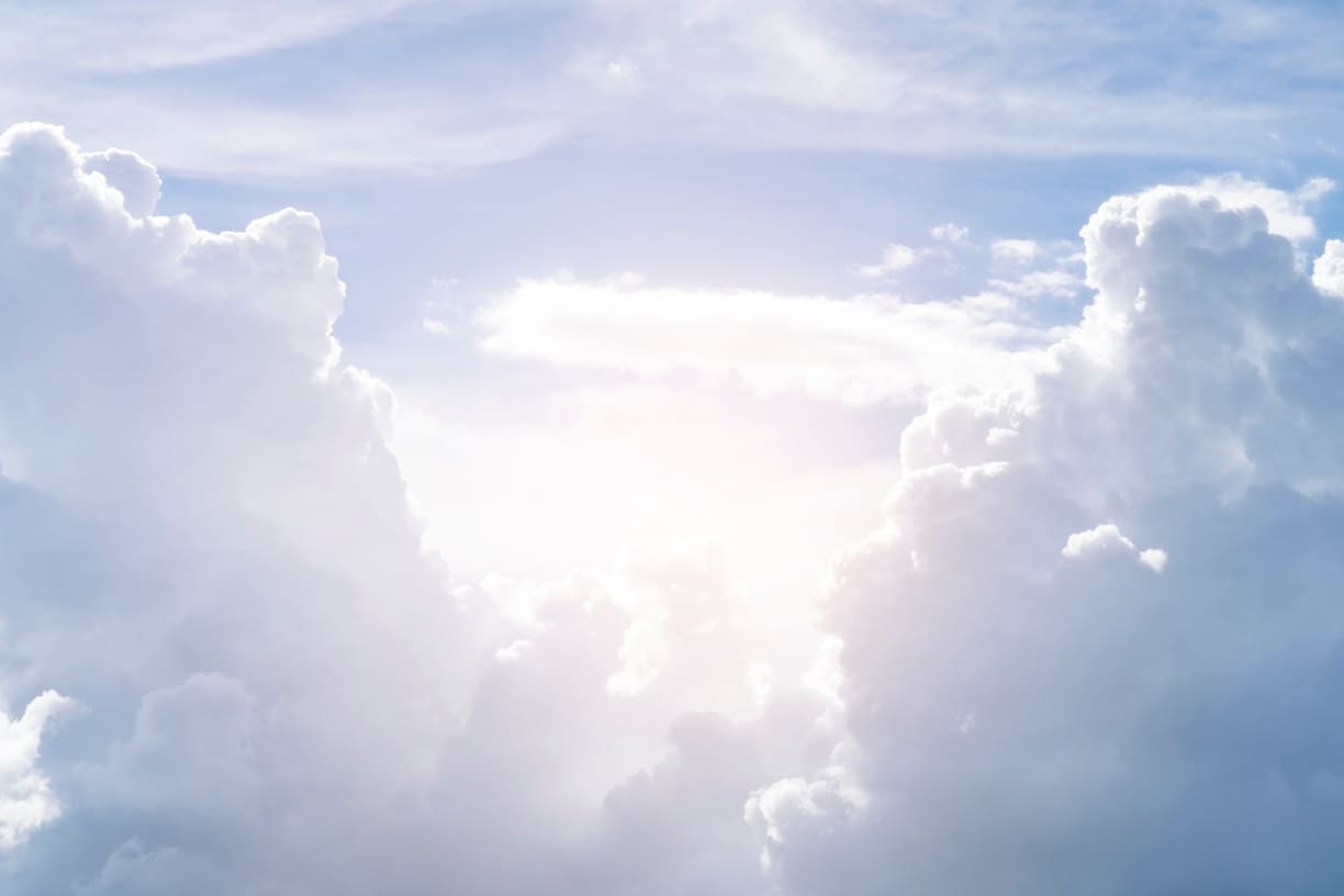 Nubes blancas y cielo azul iluminado por la luz del sol, transmitiendo tranquilidad y paz.