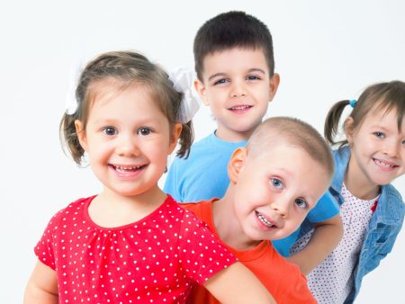 Niños pequeños sonriendo y posando juntos, mostrando felicidad y compañerismo.