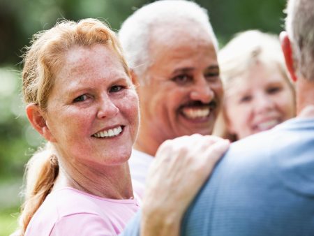 Personas adultas sonrientes compartiendo un momento juntos, transmitiendo conexión y bienestar.